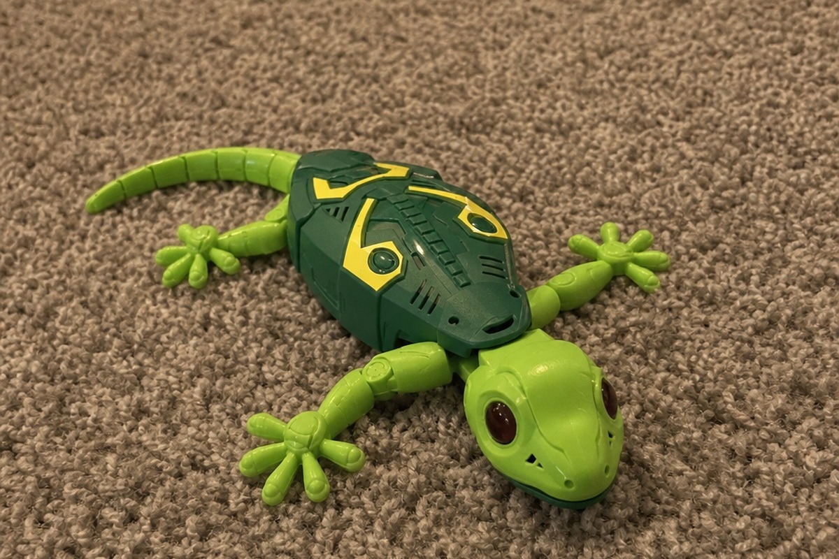 The gecko toy driving across a living room rug