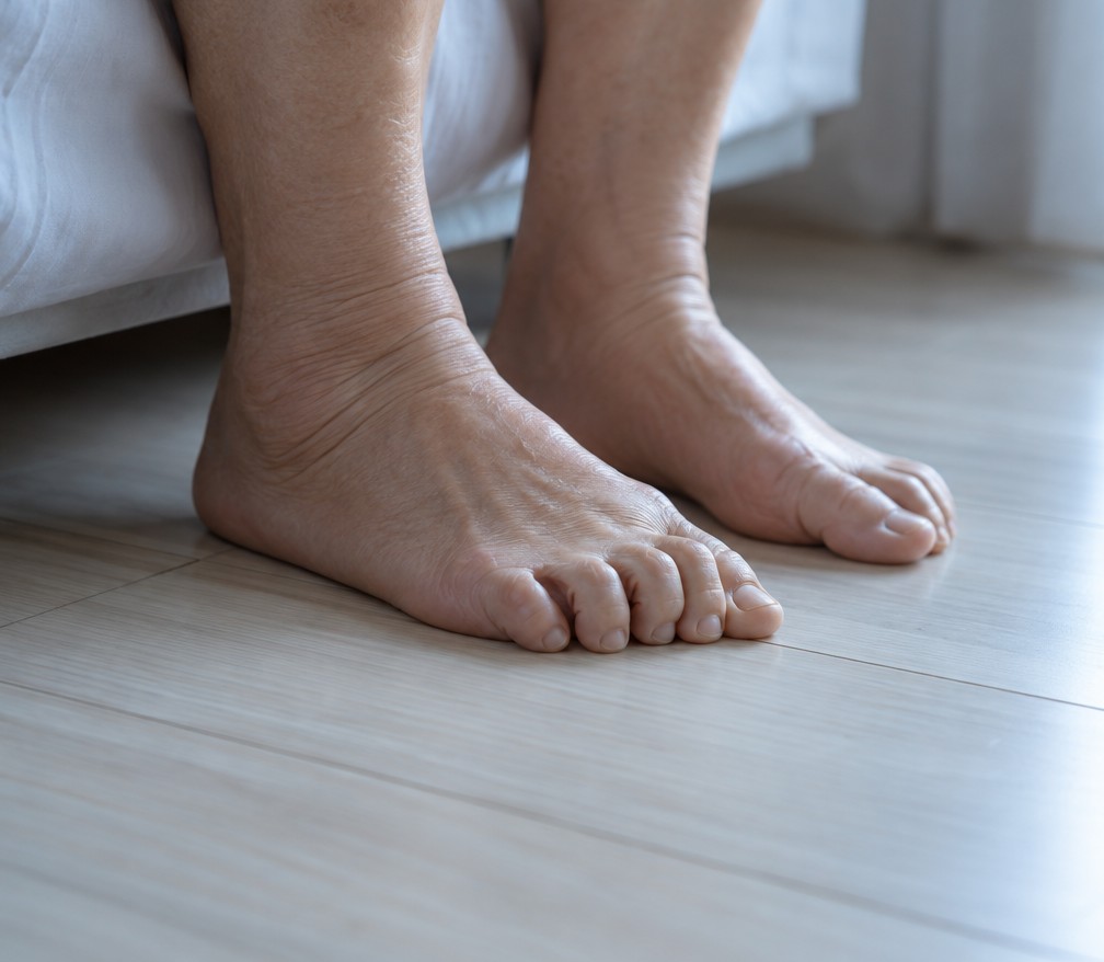 Close-up of tired bare feet on a wooden floor